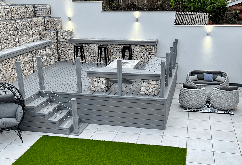 Modern outdoor decked patio with seating area, stairs, and garden furniture.