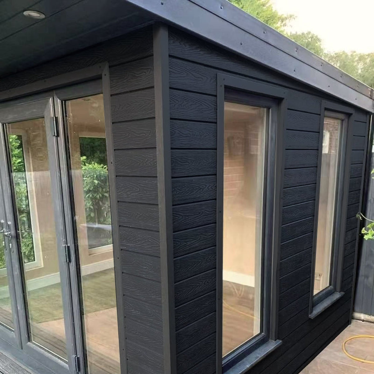 Charcoal Black Signature woodgrain shiplap cladding installed on an exterior wall