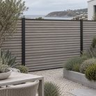 Driftwood slatted composite fencing with narrow slat faces and slim black rails — generated garden illustration